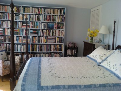 floor to ceiling bookcase and tall four poster mahogany bed and bureau